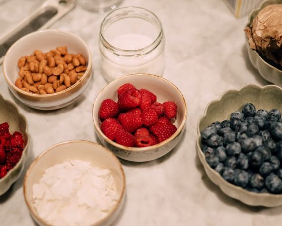 A variety of fresh berries, nuts, and ingredients in bowls perfect for breakfast or food photography.